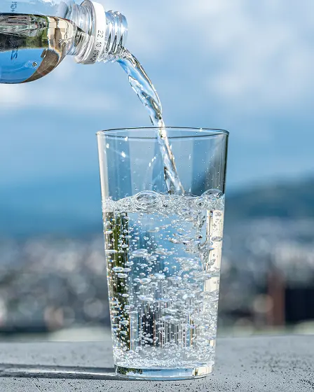 透明なグラスに水を注いでいる様子